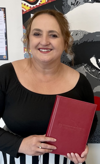 Image of Letitia Hope holding her ‘red book’.