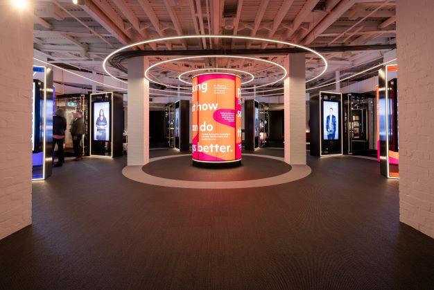 Central exhibition photo of light board with excerpts of text acknowledging public servants work.