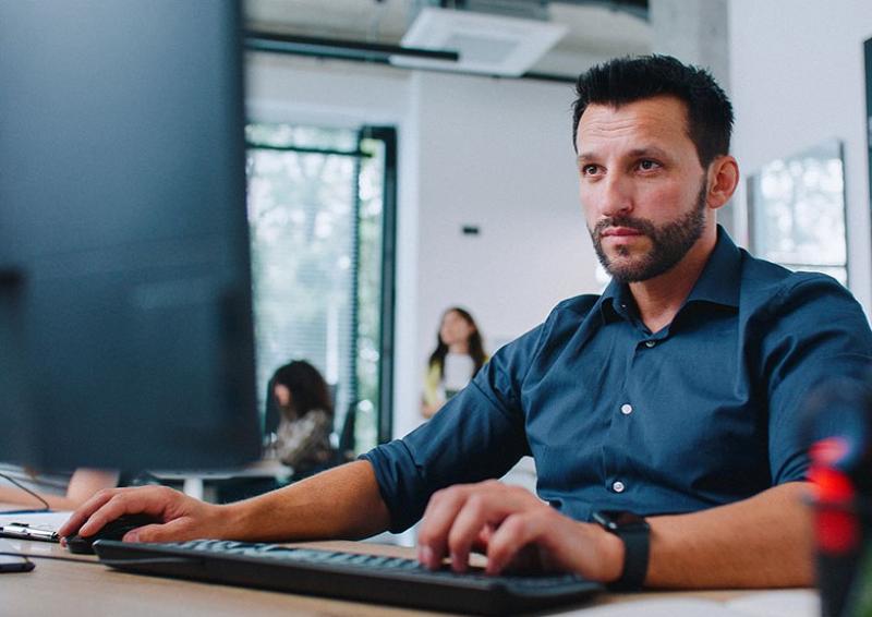 Person sitting at a desk working on a laptop